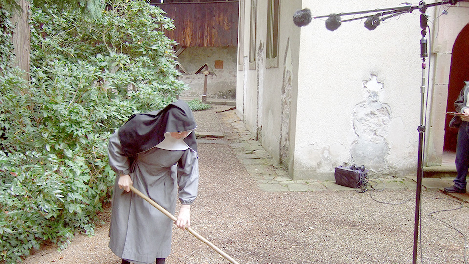 Schwester Beatrice pflegt den Klostergarten und harkt den Gehweg rund um die Einsiedlerkapelle. | © SWR/Johannes S. Sistermanns