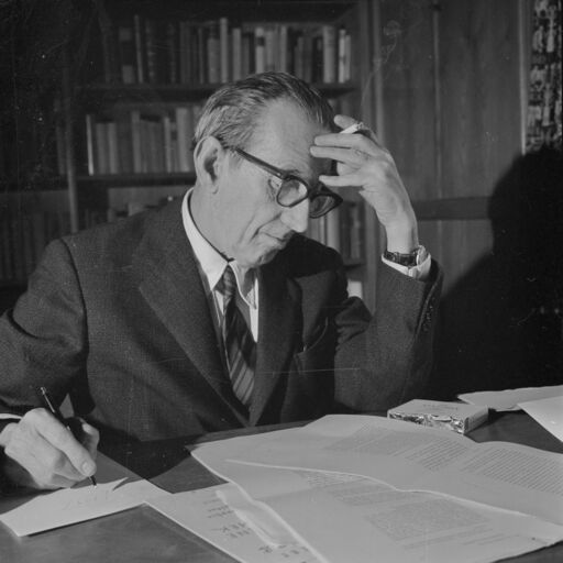 Walter Mehring liest auf Schreibtisch vor ihm liegenden Text